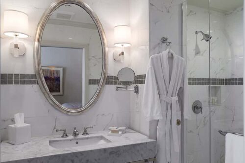 penthouse bathroom sink with granite counter large mirror bathrobe and shower stall
