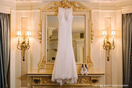 Wedding dress hanging in front of mirror
