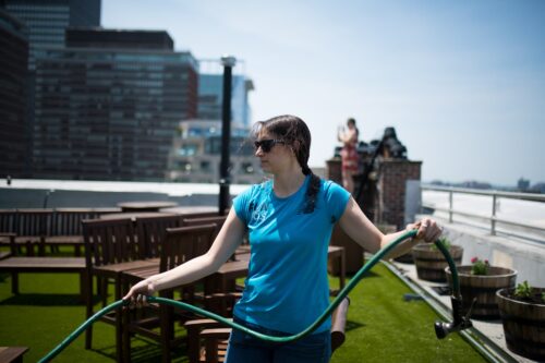 Director of Responsibility, Samantha Sorrin, getting ready to water the rooftop garden