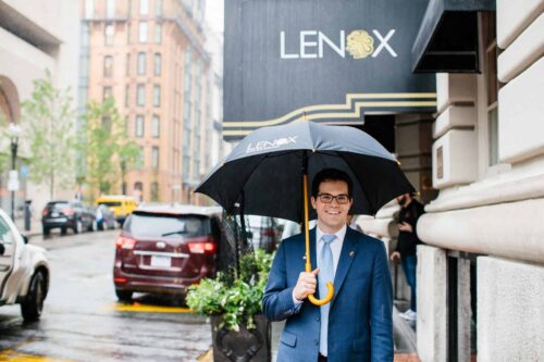 Lenox employee outside Lenox with an umbrella
